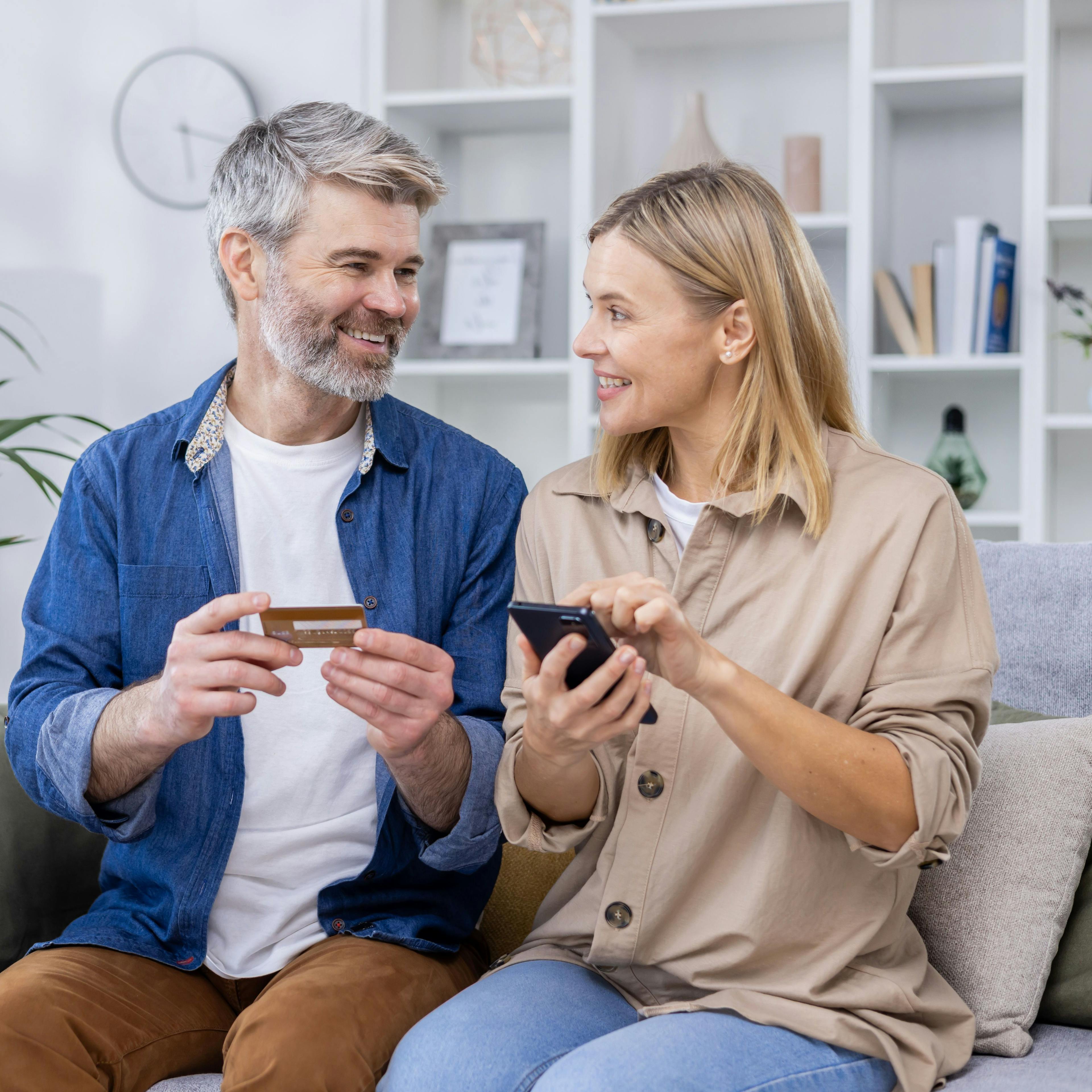 Happy couple paying online with credit card